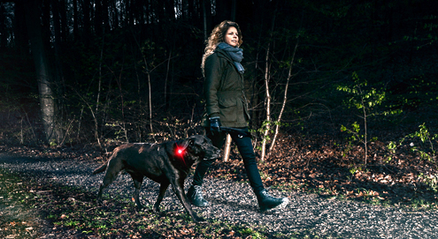 vrouw met zwarte hond in het donker