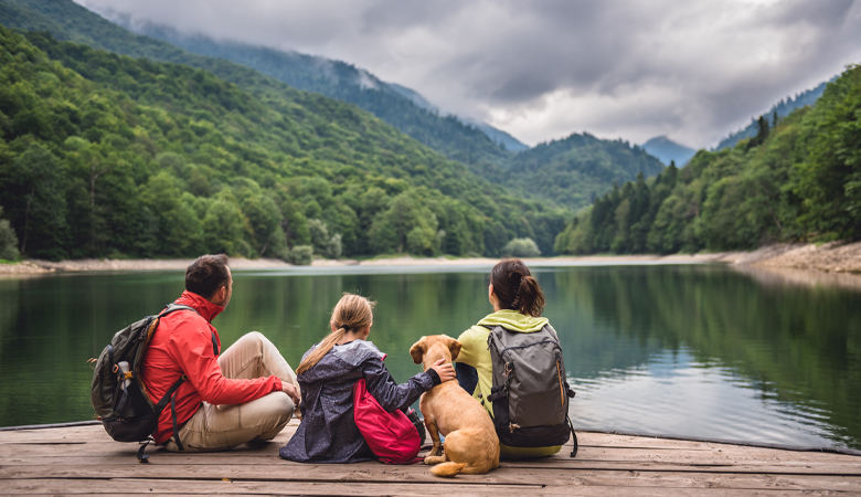 Familie met hond aan meer