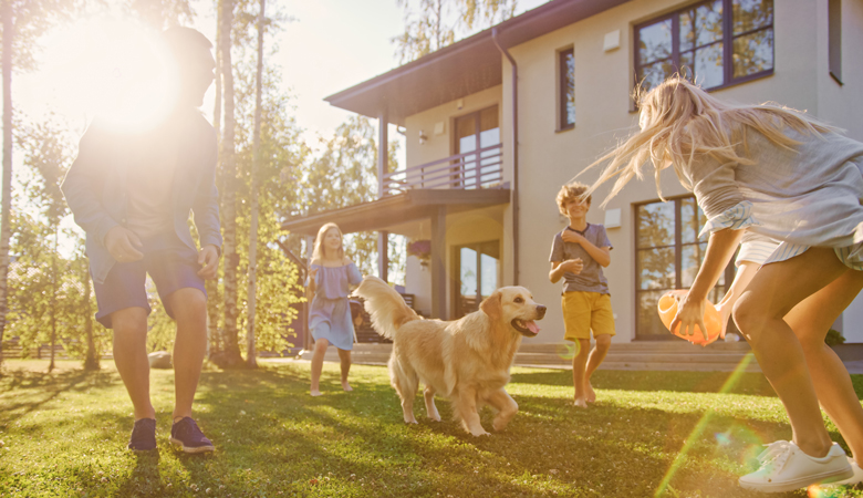 Familie spielt mit einem Golden Retriever Ball