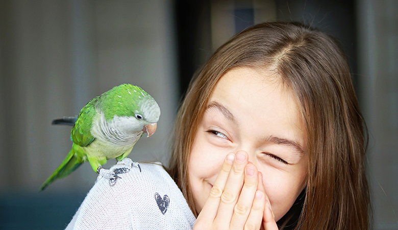 vogel zit bij meisje op schouder