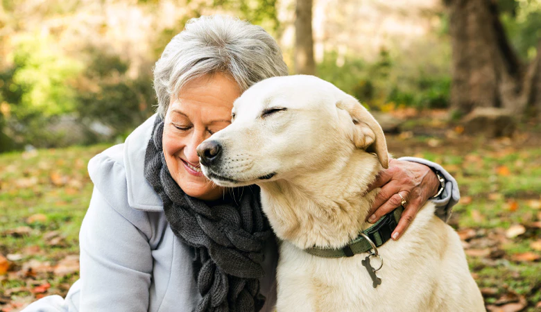 vrouw en hond omhelzing in het bos